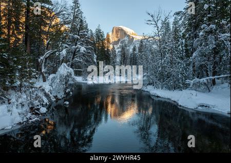 Halbkuppel spiegelt sich im merced River, während er von der untergehenden Sonne beleuchtet wird. Yosemite-Nationalpark. Stockfoto