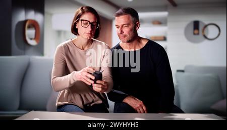 Paar sitzt auf dem Sofa hören die Musik auf kabellose Lautsprecher Stockfoto