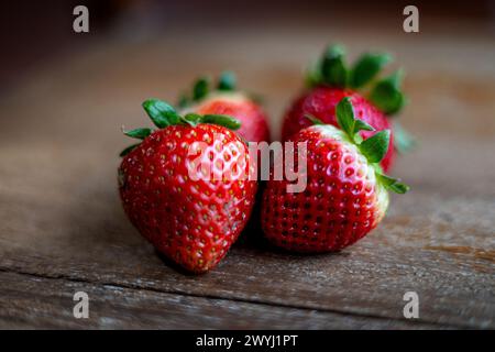 Gesunde Ernährung. Frische, reife Erdbeeren auf braunem Hintergrund. Frische Bio-Erdbeeren auf altem Holz. Stockfoto