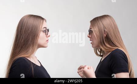 Identische Frauen führen eine stille Debatte, ihre Äußerungen sind in Kommunikation eingeschlossen Stockfoto