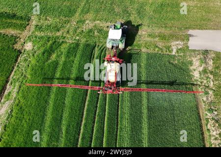 Themenfoto Landwirtschaft,Duengen,Pestizide, ein Landwirt faehrt mit seinenm Traktor ueber ein gruenes Feld und duengt mit Pestiziden. *** Themenfoto Landwirtschaft, Duengen, Pestizide, Ein Landwirt fährt seinen Traktor über ein grünes Feld und düngt mit Pestiziden Stockfoto