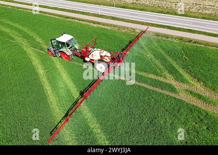 Themenfoto Landwirtschaft,Duengen,Pestizide, ein Landwirt faehrt mit seinenm Traktor ueber ein gruenes Feld und duengt mit Pestiziden. *** Themenfoto Landwirtschaft, Duengen, Pestizide, Ein Landwirt fährt seinen Traktor über ein grünes Feld und düngt mit Pestiziden Stockfoto