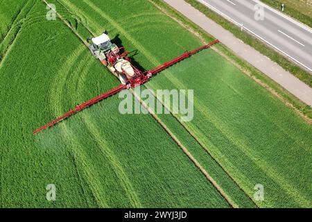 Themenfoto Landwirtschaft,Duengen,Pestizide, ein Landwirt faehrt mit seinenm Traktor ueber ein gruenes Feld und duengt mit Pestiziden. *** Themenfoto Landwirtschaft, Duengen, Pestizide, Ein Landwirt fährt seinen Traktor über ein grünes Feld und düngt mit Pestiziden Stockfoto