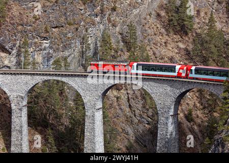 Glacier Express vorbei am Landwasserviadukt vom Aussichtspunkt Tschaingels. Stockfoto