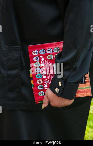 London, Großbritannien. April 2024. Eine Frau hält afrozentrische Bücher auf dem Windrush Square, Brixton. Anhänger und religiöse Führer versammelten sich am Windrush Square in Brixton, um an die Menschen zu erinnern, die von der harten und unfairen Politik betroffen waren, die 2018 öffentliche Aufmerksamkeit erhielt, und die Regierung sah sich mit Gegenreaktionen über die Behandlung der Windrush-Generation konfrontiert. Quelle: SOPA Images Limited/Alamy Live News Stockfoto