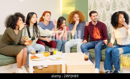 Gruppe von Freunden zu Hause, die ein Spiel im Fernsehen ansehen Stockfoto