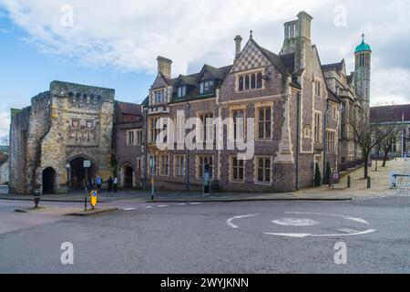 High Street, Winchester, Vereinigtes Königreich - 18. Februar 2024: Die Büros von Castle Hill aus dem 19. Jahrhundert und das mittelalterliche Stadttor, das heute das Westgate Museum ist. Stockfoto