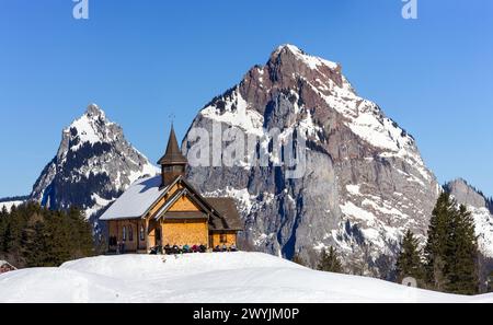 Stoos, Schweiz - 09. Februar 2022: Panorama des berühmten Alpenskigebietes Stoos mit der Marie-Hilf-Kapelle und dem Gross und Klein Mythen Stockfoto