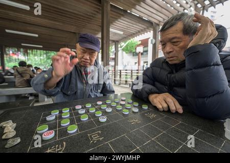 Senior-Männer konzentrierten sich stark auf ein strategisches Brettspiel Stockfoto