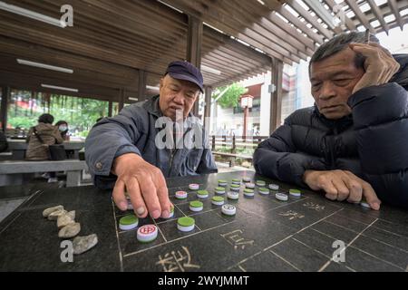 Senior-Männer konzentrierten sich stark auf ein strategisches Brettspiel Stockfoto