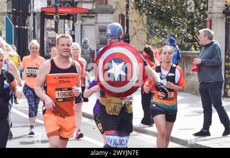 London, Großbritannien. April 2024. Ein Läufer, der als Captain America verkleidet ist, nimmt am London Landmarks Half Marathon in Central London Teil. Quelle: Vuk Valcic/Alamy Live News Stockfoto