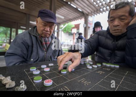 Senior-Männer konzentrierten sich stark auf ein strategisches Brettspiel Stockfoto