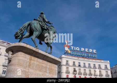 Spanien, Madrid, Puerta del Sol, Reiterstatue von König Karl III. Und Weinwerbung Tio Pepe auf einem Dach eines Gebäudes Stockfoto