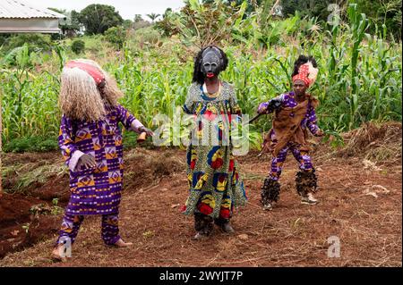 Kamerun, Westteil, Bezirk Ndé, Bagangté, Beerdigungszeremonie, 2 Männer in traditioneller Kleidung und ein Mann, der als Frau mit Maske verkleidet ist Stockfoto