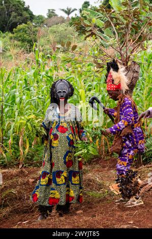 Kamerun, Westteil, Bezirk Ndé, Bagangté, Beerdigungszeremonie, ein Mann in traditioneller Kleidung und ein Mann, der als Frau verkleidet ist, mit Maske Stockfoto