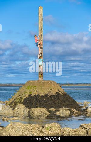 Frankreich, Vendee, die Insel Noirmoutier, Barbatre, Kinder, die bei Ebbe auf einem der Schutzhütten der Passage du Gois klettern, ein Tauchdamm, der die Insel mit dem Festland verbindet Stockfoto