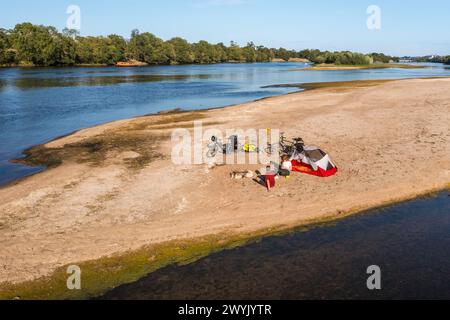 Frankreich, Maine-et-Loire, Loire-Tal, das von der UNESCO zum Weltkulturerbe erklärt wurde, Radfahren am Ufer der Loire, Camping für die Nacht auf einer der Sandbänke, die Inseln an der Loire bilden, eine Gabarre (traditionelles Flachbodenboot) im Hintergrund (aus der Vogelperspektive) Stockfoto