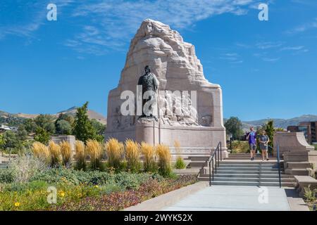 Ein Paar spaziert vorbei an der Mormon Battalion Memorial Statue auf dem Gelände des Utah Stat Capitol in Salt Lake City, Utah Stockfoto