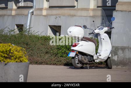 Ein weißer Roller, der auf der Straße geparkt hat Stockfoto