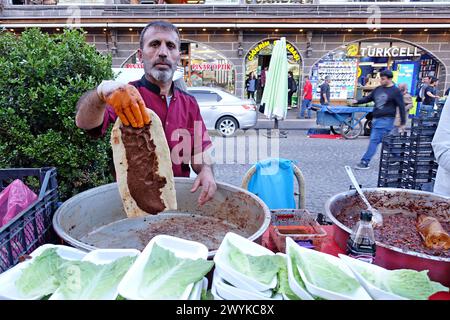 Diyarbakir, Türkei. April 2024. Ein Verkäufer verkauft und zeigt den Fleischbällchen, den er auf Brot geklebt hat. In Diyarbakir, der historischen Stadt der Türkei, gibt es Einkaufsbummel vor Eid al-Fitr. (Foto: Mehmet Masum Suer/SOPA Images/SIPA USA) Credit: SIPA USA/Alamy Live News Stockfoto