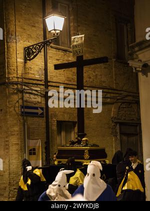 Chieti, Italien - 29. März 2024: Kapuzenpfändiger während der berühmten Karfreitagsprozession in Chieti (Italien) tragen das Kreuz mit der Aufschrift INRI Stockfoto