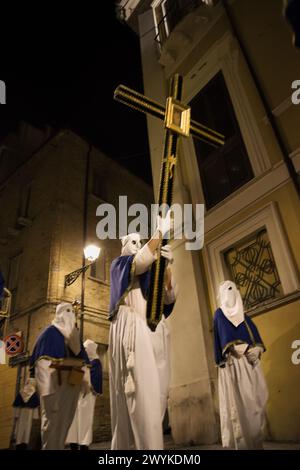 Kapuzenbüßner während der berühmten Karfreitagsprozession in Chieti (Italien) tragen das Kreuz mit dem Bildnis Jesu Stockfoto