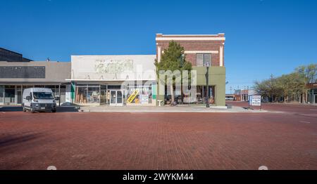 Brownfield, Texas, USA – 22. März 2024: Kreuzung mit Backsteinstraßen und Unternehmen im Stadtzentrum Stockfoto