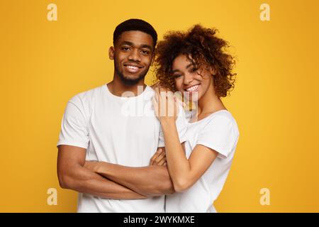 Junge afroamerikanische Paare posieren auf orangefarbenem Hintergrund Stockfoto