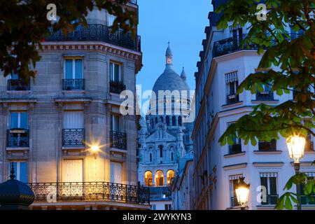 Die berühmte Sacre-coeur-Basilika zwischen haussmann-Gebäuden in Paris am Abend. Frankreich. Stockfoto