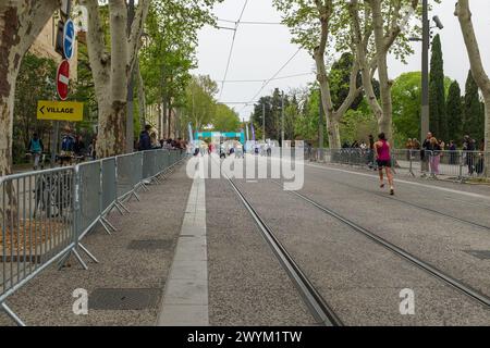 Montpellier, Frankreich. April 2024. Eine junge Frau, die sich vor dem Botanischen Garten vor dem Halbmarathon des Montpellier Run Festivals aufwärmt. Credit ReportageMPL/Alamy Live News Stockfoto