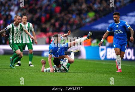 Harrison Burrows (TOP) von Peterborough United wird im Finale der Bristol Street Motors Trophy im Wembley Stadium, London, von Christian Joseph der Wycombe Wanderers herausgefordert. Bilddatum: Sonntag, 7. April 2024. Stockfoto