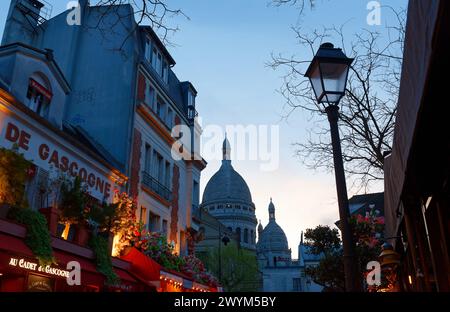 Die Vorderseite des Restaurants Au Cadet de Gascogne am Place du Tertre im berühmten Viertel Montmartre bei Nacht. Stockfoto