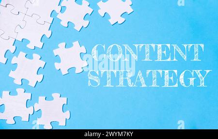 Ein Puzzle mit dem Wort Inhaltsstrategie. Die Puzzleteile sind im Bild verstreut und erzeugen ein Gefühl von Unordnung und Kompl Stockfoto