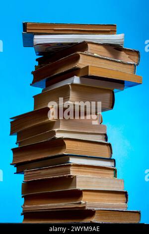 Ein Stapel alter Bücher und Notizbücher auf dem Tisch auf blauem Hintergrund Stockfoto