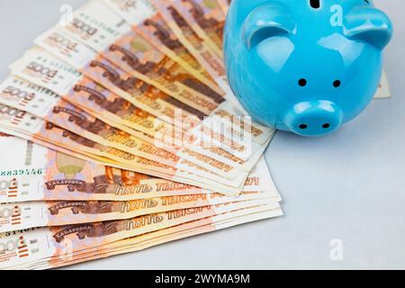 Schweinebank und russische Banknoten auf grauem Hintergrund. Der Begriff der Akkumulation und Speicherung von Geld. Stockfoto