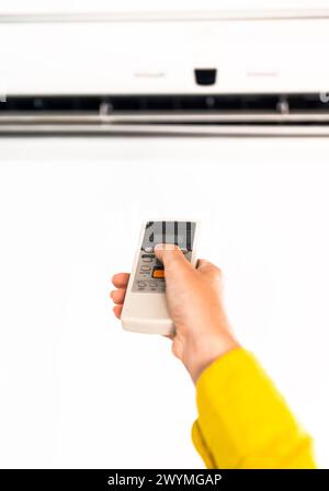Hand, die Fernbedienung auf die Klimaanlage. Stockfoto