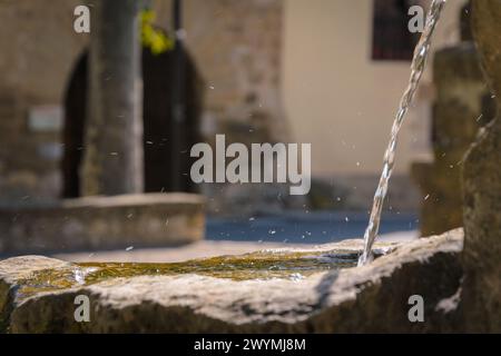 Wasserstrahl in einem Steinbrunnen auf der Straße eines historischen Dorfes, Rubielos de Mora, Teruel, Spanien Stockfoto