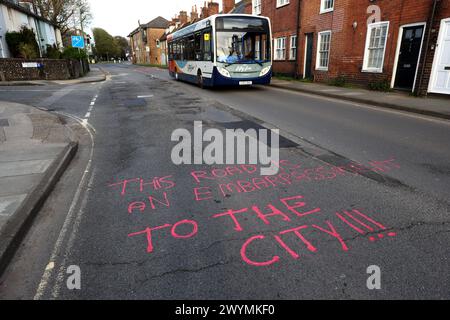 Graffiti auf den Straßen von Chichester, West Sussex, Großbritannien, beschweren sich nach Jahren der Vernachlässigung über die Topflöcher und den Zustand der Straßen. Stockfoto