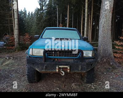 Alter SUV-Wagen mit Winde im Wald, Vorderansicht Stockfoto