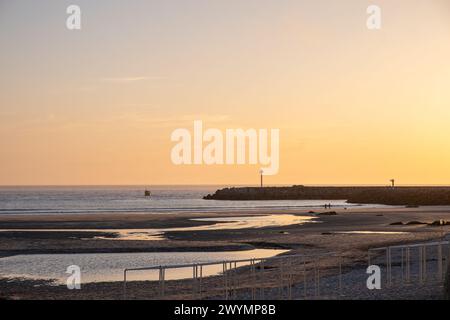 Sonnenuntergangslandschaft eines Schiffes, das in einen Hafen einfährt Stockfoto