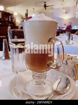 Inneneinrichtung des Bistro Les Amis Restaurant in SoHo, NYC, USA, 2024, Glasbecher mit Cappuccino Stockfoto