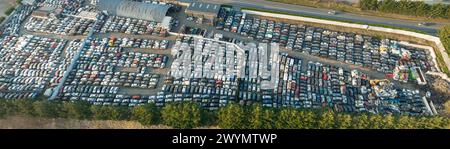 Luftaufnahme des großen Parkplatzes von Schrottplatz mit Reihen von weggeworfenen gebrochenen Autos. Recycling von Altfahrzeugen Stockfoto