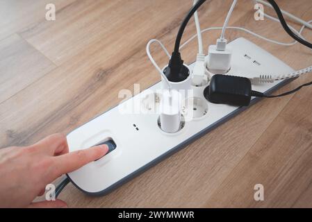 Mann, der den Netzstecker einsteckt. Steckdose zu Hause. Stockfoto