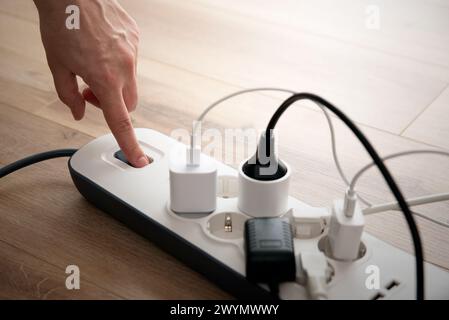 Mann, der den Netzstecker einsteckt. Steckdose zu Hause. Stockfoto