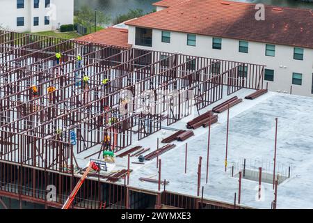 Baustelle mit vielen Arbeitern und Ausrüstung in Fort Myers, Florida. Harte Arbeit bei der kommerziellen Entwicklung Stockfoto