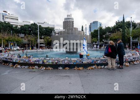 Zwei Frauen besuchen die Gedenkstätte, um ihren Respekt auf dem Dizengoff-Platz zu erweisen. Der Brunnen auf dem Dizengoff-Platz ist einer der Orte in Tel Aviv geworden, an denen Menschen provisorische Gedenkstätten für diejenigen schaffen, die während des Angriffs der Hamas am 7. Oktober 2023 getötet und entführt wurden. Stockfoto
