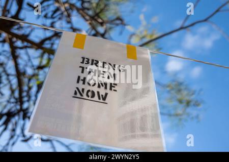 Tel Aviv, Israel. März 2024. Auf einem Plakat zwischen Bäumen steht einfach „Bring sie jetzt nach Hause“. Der Brunnen auf dem Dizengoff-Platz ist einer der Orte in Tel Aviv geworden, an denen Menschen provisorische Gedenkstätten für diejenigen schaffen, die während des Angriffs der Hamas am 7. Oktober 2023 getötet und entführt wurden. (Credit Image: © Syndi Pilar/SOPA Images via ZUMA Press Wire) NUR REDAKTIONELLE VERWENDUNG! Nicht für kommerzielle ZWECKE! Stockfoto