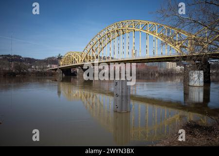 Entlang des Strip District in Pittsburgh reflektiert die gelbe Sixteenth Street Bridge das ruhige Wasser des Allegheny River Stockfoto