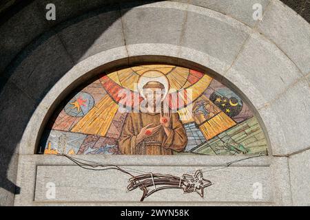 Varese, Lombardei, Italien. Kirche St. Franziskus von Assisi, von den Kapuzinerbrüdern, in der Struktur befindet sich auch ein Kloster. Fresko auf der Lünette über der Eingangstür, das den Heiligen Franz von Assisi zeigt und die Stigmata zeigt. Stockfoto