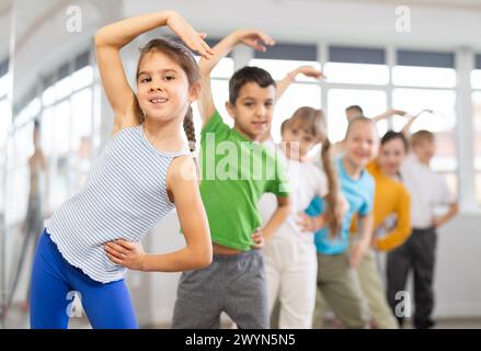 Gruppe von Kindern, die sich vor dem Tanzkurs aufwärmen Stockfoto